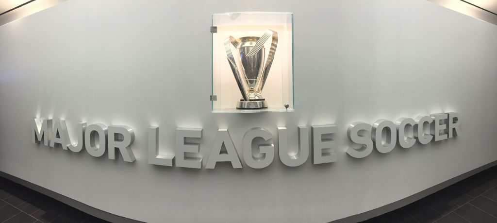 Primul lucru pe care-l vezi când intri în sediul din Manhattan al MLS este MLS Cup, trofeul suprem al campionatului nord-american de fotbal.